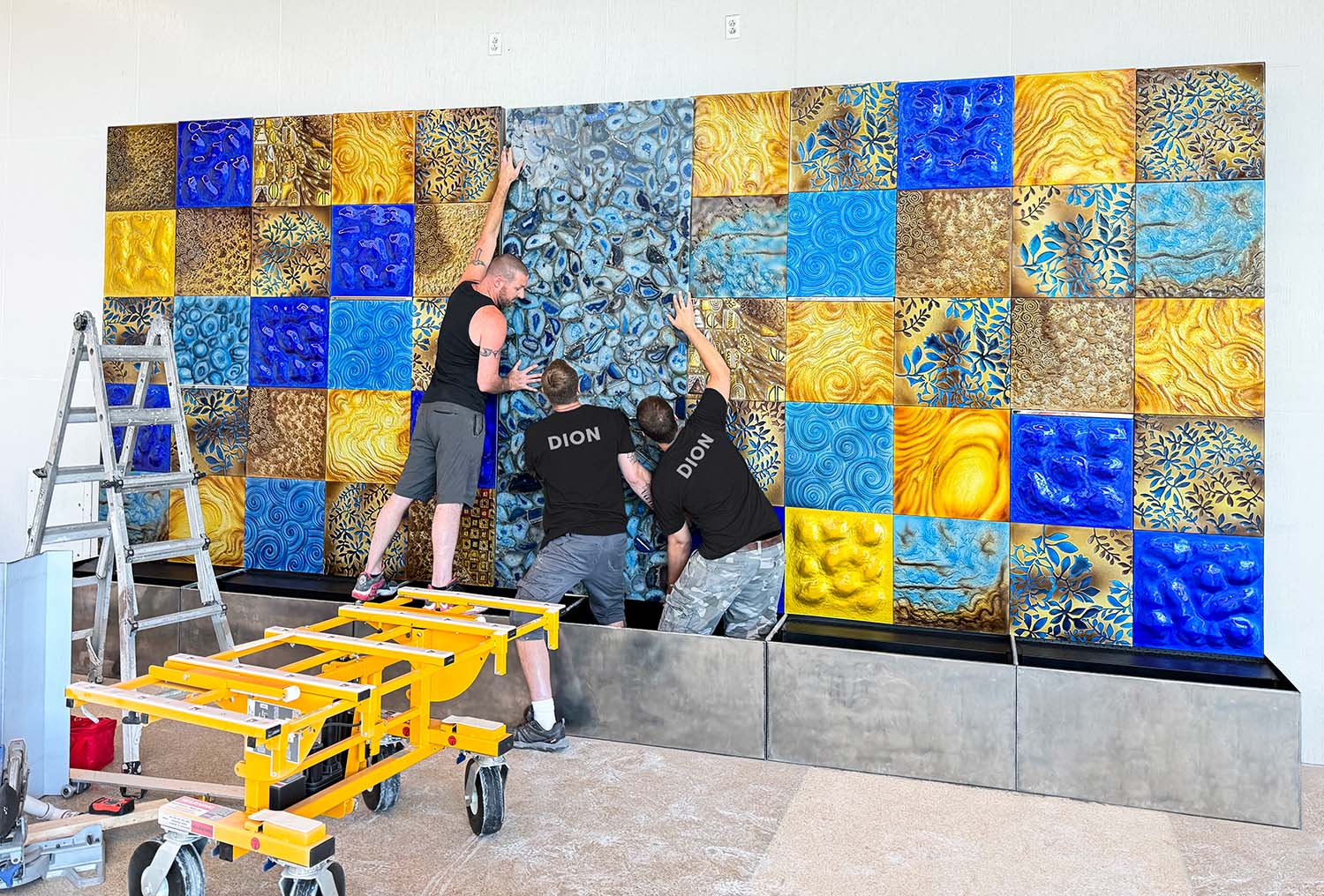 Installation team DION assembling a decorative wall with colorful square panels