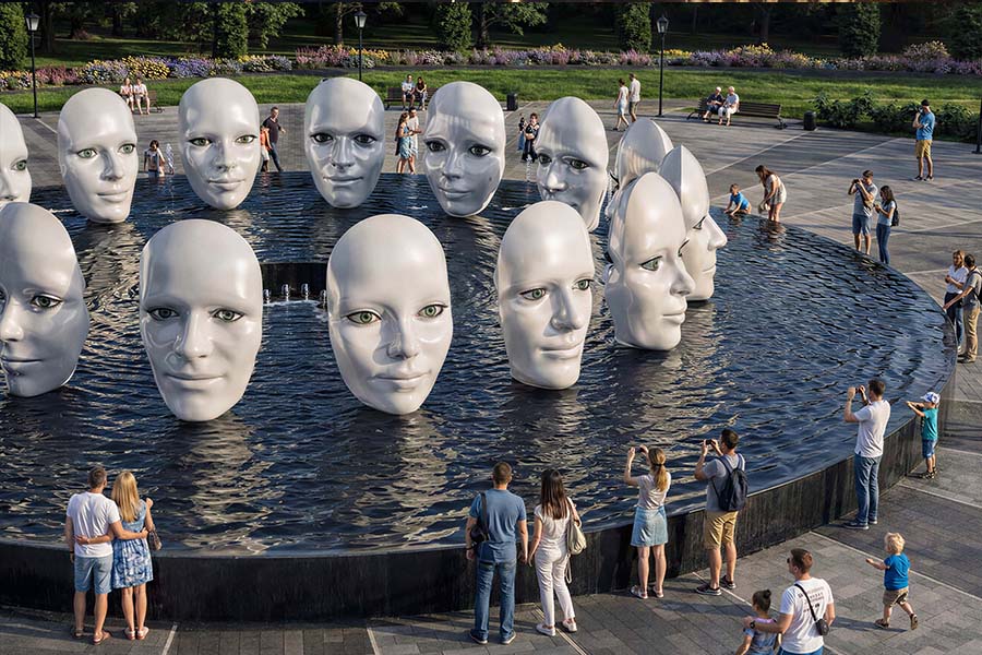 Public art fountain with sculptural faces