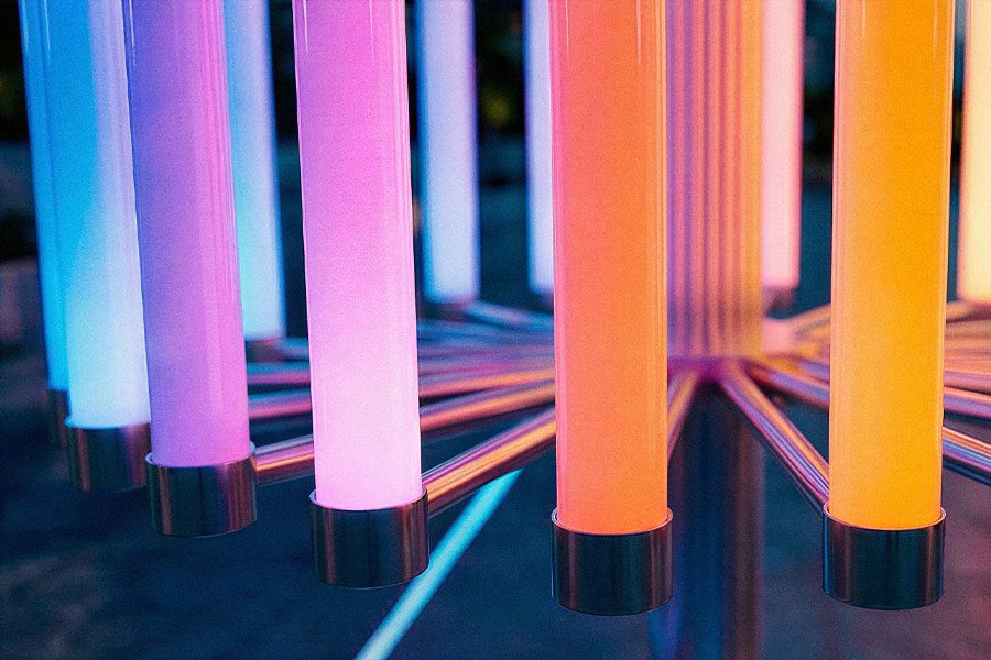 Close-up of the illuminated polycarbonate tubes in the “Pulse of Light” installation, suspended in a circular композиция and glowing with smooth gradients of blue, pink, and warm amber. Each element emits a soft, even light, emphasizing the materiality of light itself and showcasing the technological precision and atmospheric depth of the interactive public art system.